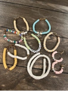 Assorted colorful beaded jewelry pieces, including bracelets and earrings, arranged on a wooden surface.