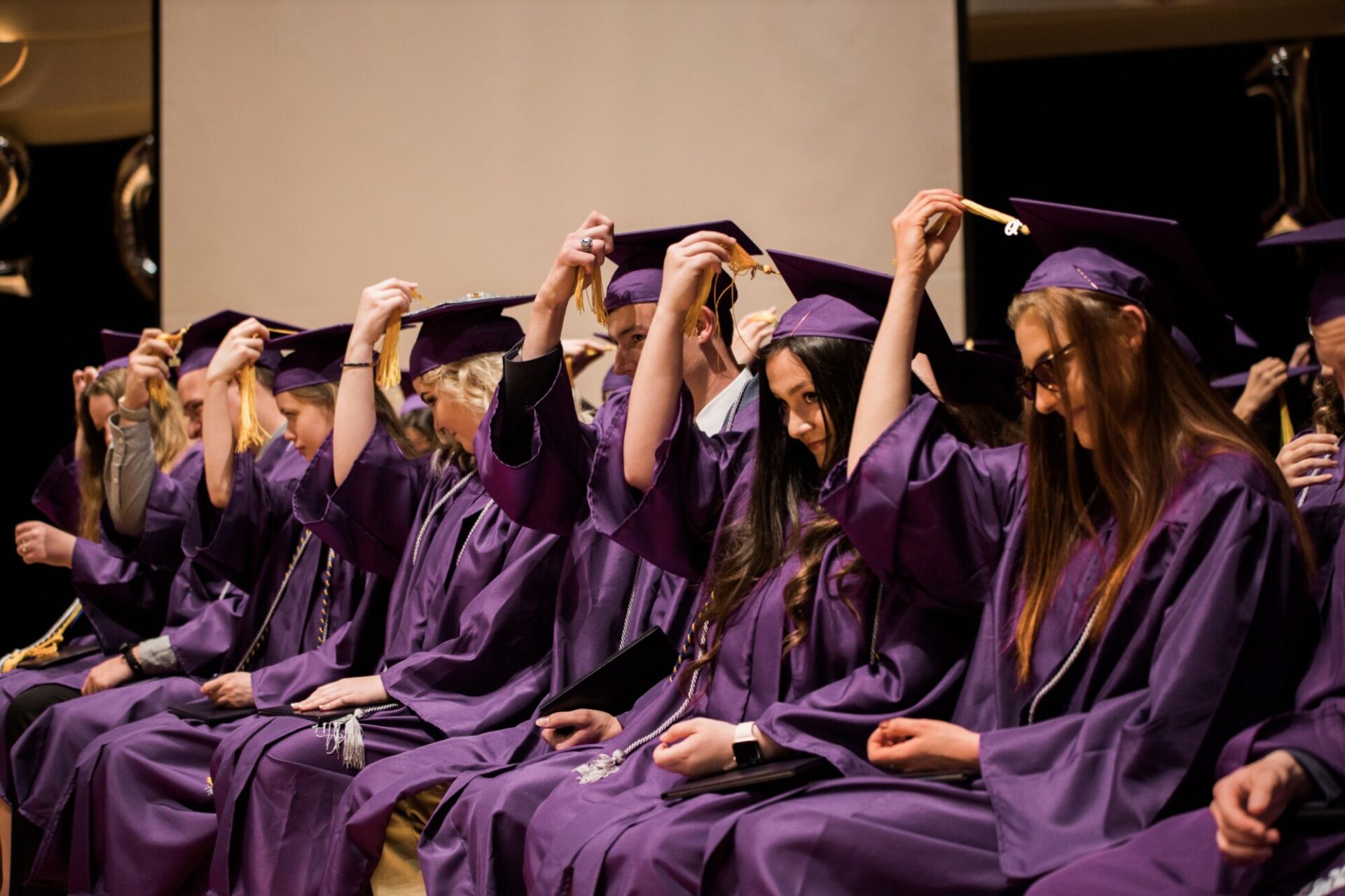 Recent graduates touching their square academic cap