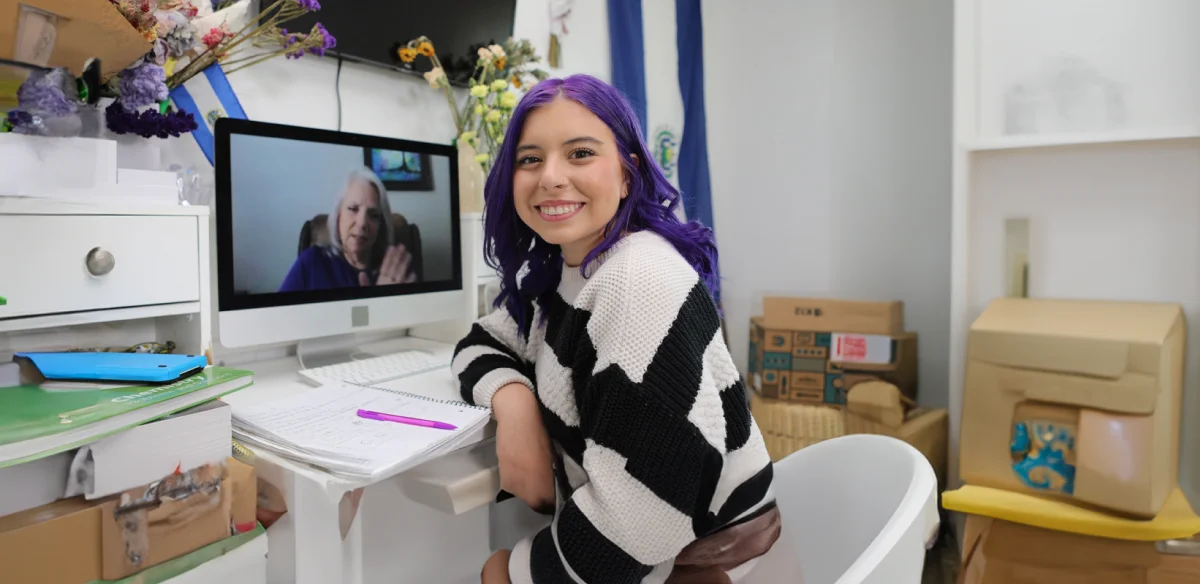 Student attending to an online class wearing a stripped sweater