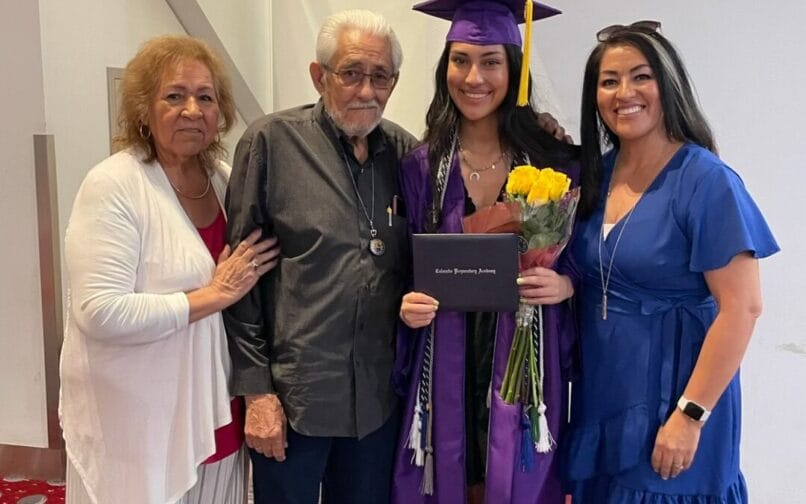A student who graduated taking a photo with he rfamily