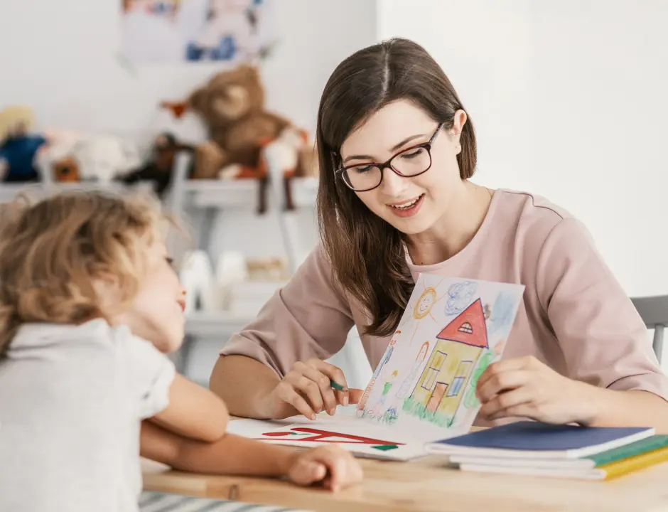 Early education student with a little girl talking about a drawing