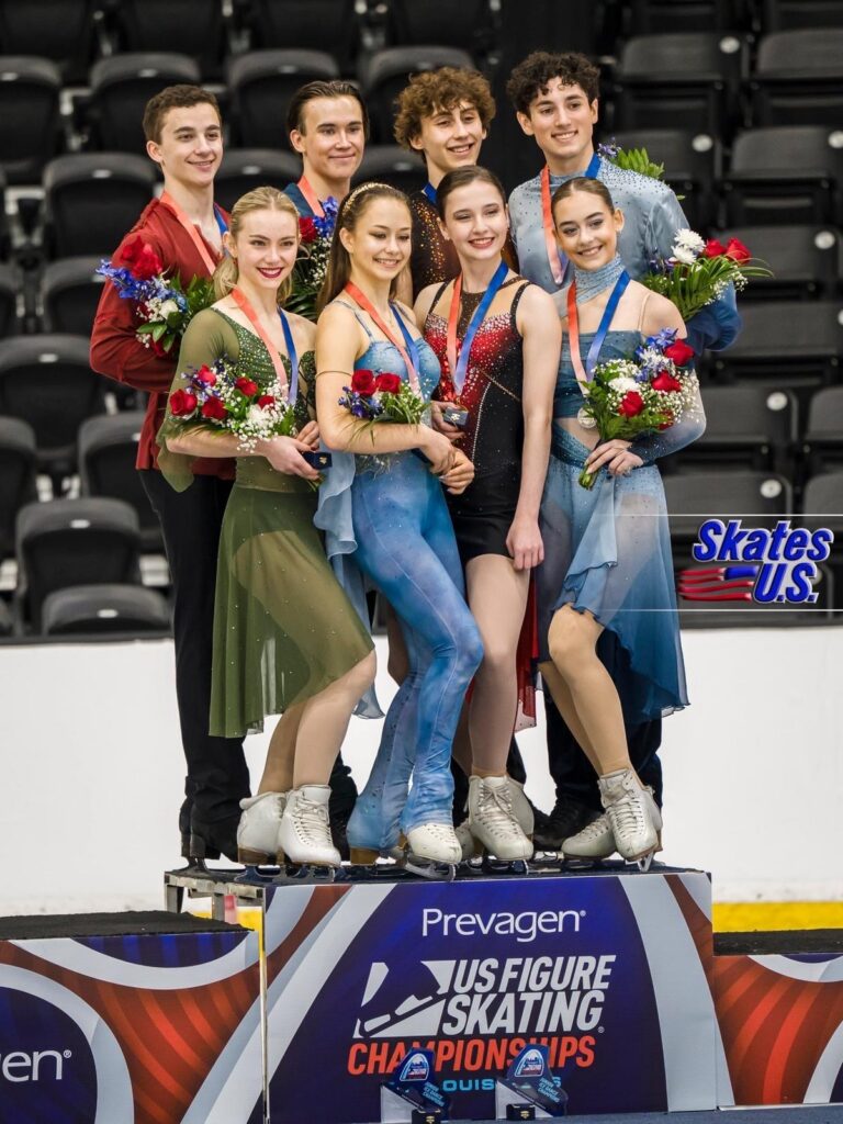 Jane Calhoun and fellow medal-winning figure skaters pose together on the awards podium.
