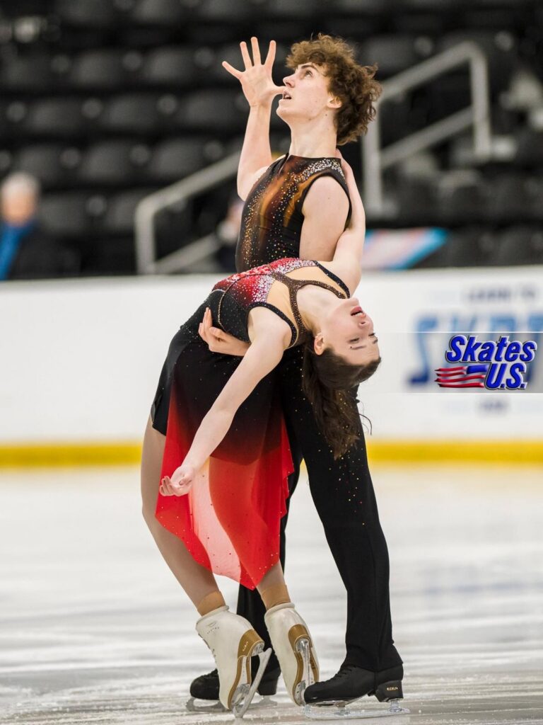 Jane Calhoun performs a dramatic ice dance move with her partner during a figure skating competition.